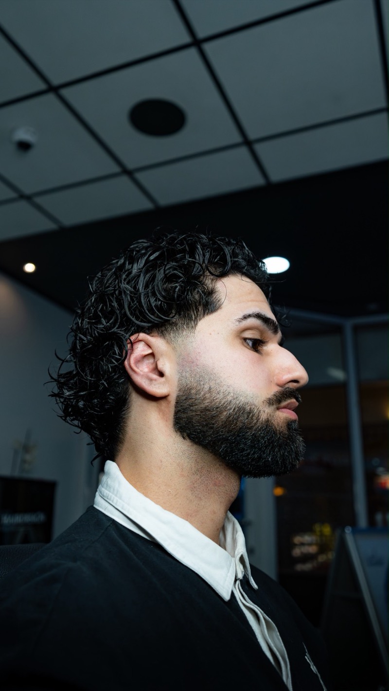 Lockiger Mullet mit Fade und Bart
